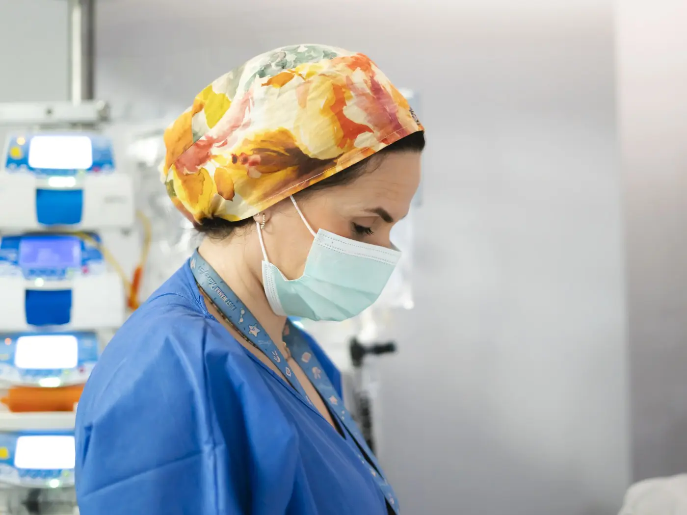 Healthcare worker in scrubs and mask.