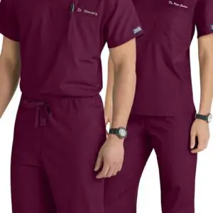 Two people wearing matching burgundy medical scrubs.