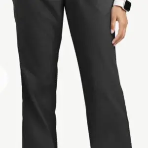 Close-up of black pants worn by a person with a smartwatch.